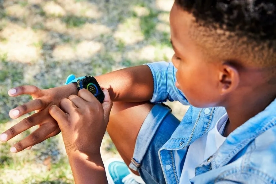 Enfant portant une montre connectée GPS adaptée à son âge, en sécurité pendant ses activités extérieures